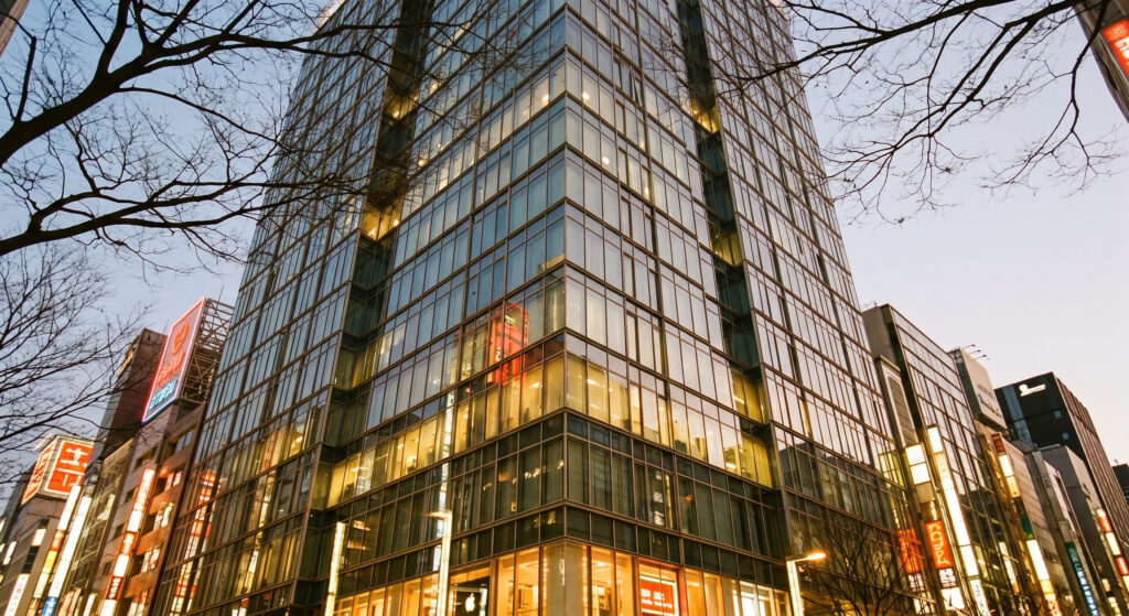 銀座の貸切結婚式場ラシックアンジュールが入る銀座2丁目のガラス張りビル外観。夕暮れ時の銀座の街並みと煌めく夜景を背景に都心ウェディングのロケーションを表現。